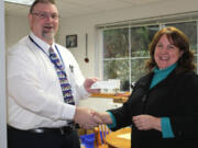 Battle Ground: Summit View High School Principal Bill Penrose, left, greets Chris Burt from the Battle Ground Education Foundation as she handed him a scholarship check for $300.