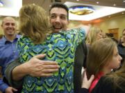 Ryan Bird is embraced by family and friends at the annual Amerian Red Cross Real Heroes Breakfast after being awarded a fire rescue hero award Friday.