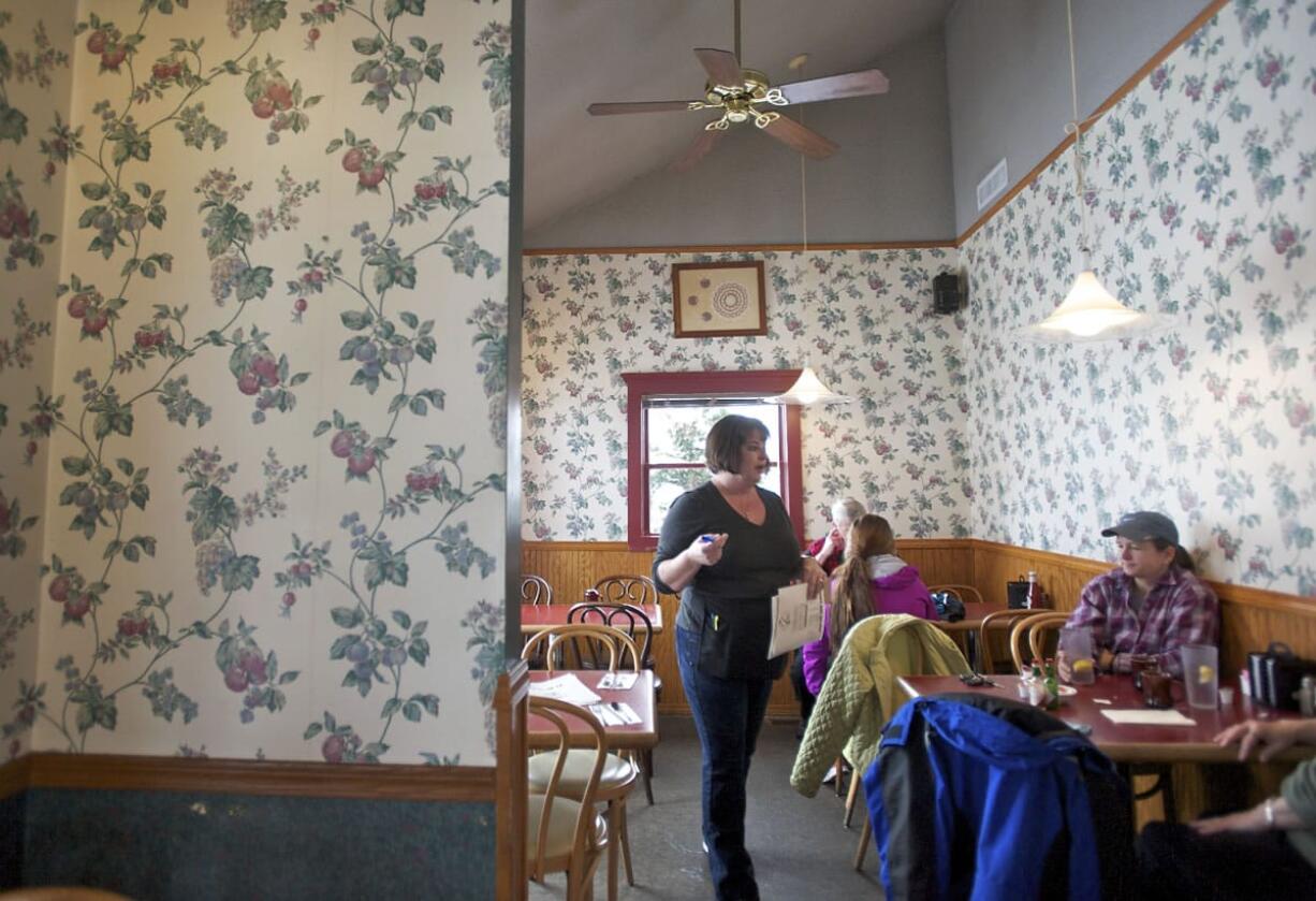 Diane Benckendorf, a server at Christine's Restaurant, takes orders at the Vancouver venue, which was open during normal business hours  Monday.