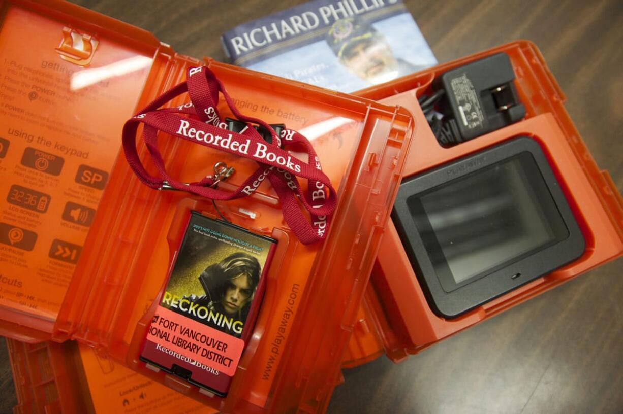 Playaway audio book and Playaway video unit in their protective cases, with a hardcover copy of &quot;A Captain's Duty&quot; by Richard Phillips.