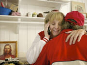 Multitasking hostess Michele Kruchoski takes a phone call while welcoming fellow volunteer Albert Fletcher to Martha's Pantry, a food pantry and community center for people with HIV/AIDS.