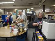 Northside Baptist Church members John Martin, center, and Cathy White, right, prepare coffee drinks for teachers and staff during a coffee cart event Nov. 10 at Gaiser Middle School. Volunteers from the church visit Gaiser and four elementary schools each month to treat teachers.