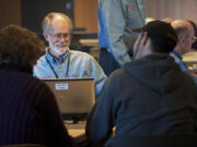 Volunteer Tax Aide Rich Watters greets Judy and Michael Johnson before digging into their taxes at the Vancouver Community Library in 2015..