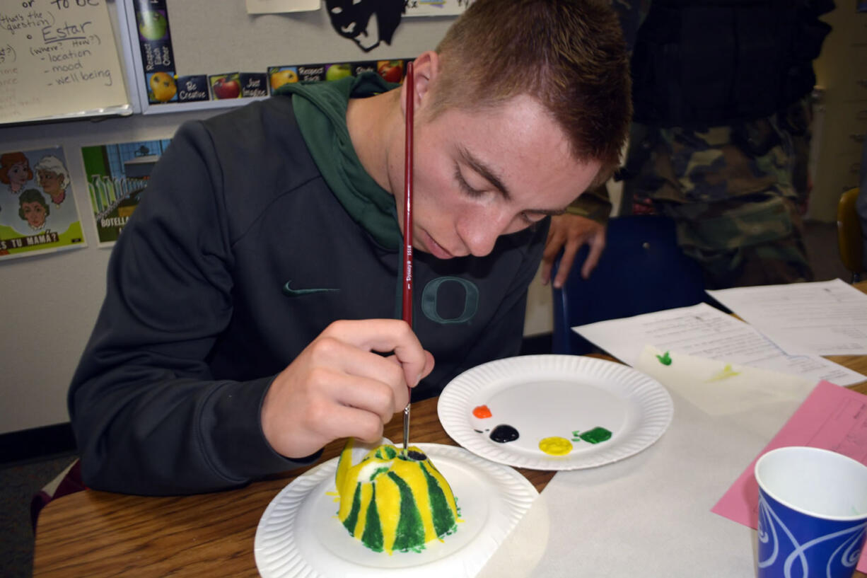 Washougal: Washougal High School Spanish language student Robert Jacobs paints a sugar skull in University of Oregon colors during a fall class lesson on Dia de los Muertos, the &quot;Day of the Dead.&quot;