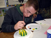 Washougal: Washougal High School Spanish language student Robert Jacobs paints a sugar skull in University of Oregon colors during a fall class lesson on Dia de los Muertos, the &quot;Day of the Dead.&quot;