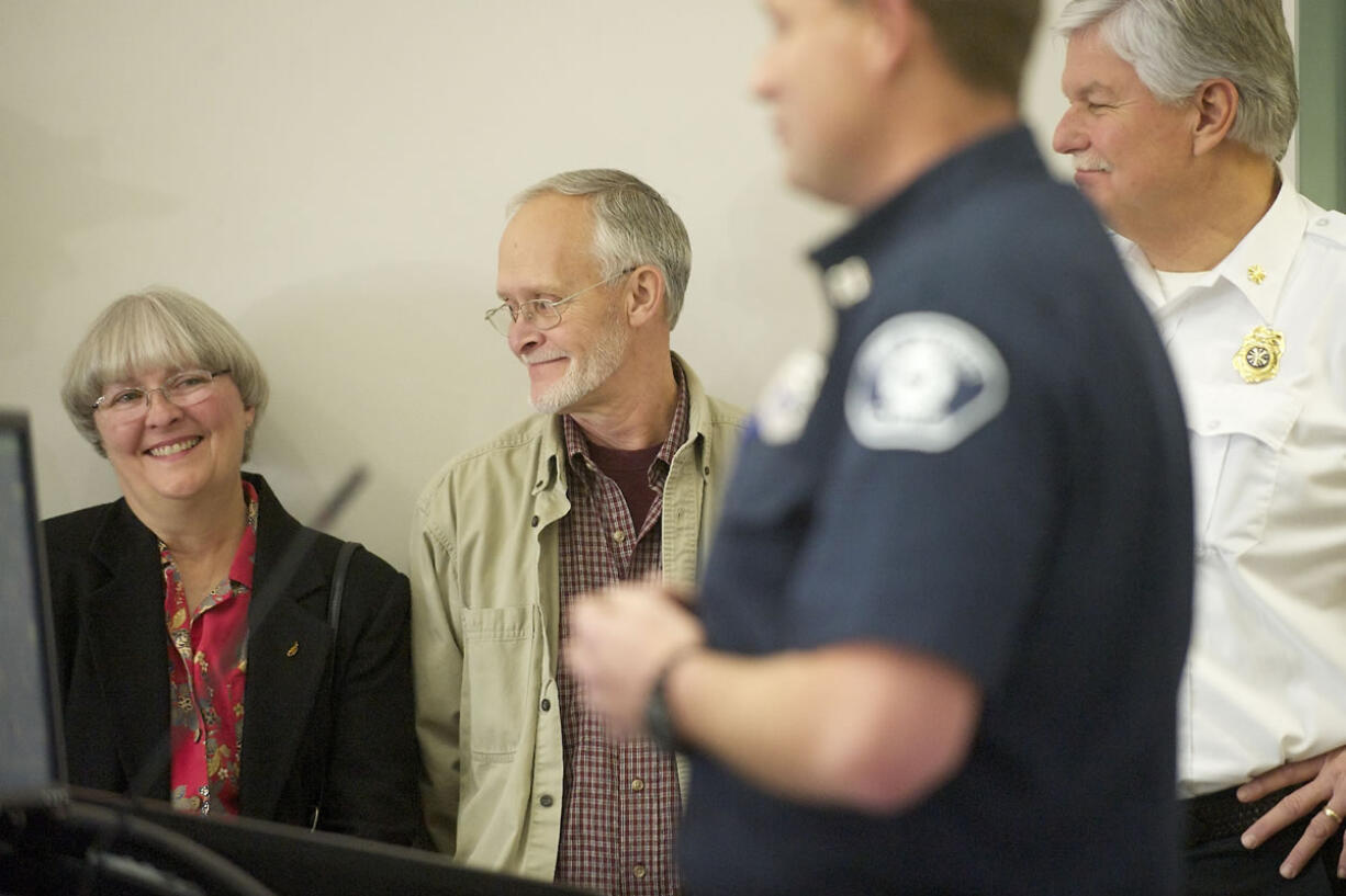 Candace Yarnell, left, smiles next to her husband, Herschel Yarnell, as Capt. Jason Mansfield of Fire District 3 talks during a PulsePoint media conference on Friday. Candace saved her husband's life earlier this year with help from a CRESA dispatcher when her husband went into cardiac arrest.