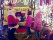 La Center: Bryan Miller, as Santa, helps children craft wreaths after they visited his home's Christmas display Dec.