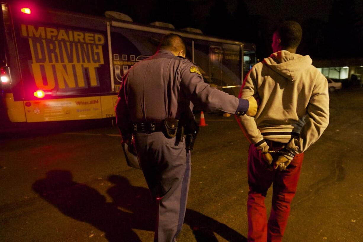 Trooper Ben Taylor delivers the first suspected drunk driver to the WSP Mobile Impared Driving Unit on the annual Night of 1000 Stars drunk driving emphasis patrol, Friday, December 6, 2013.(Steven Lane/The Columbian)