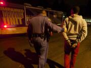 Trooper Ben Taylor delivers the first suspected drunk driver to the WSP Mobile Impared Driving Unit on the annual Night of 1000 Stars drunk driving emphasis patrol, Friday, December 6, 2013.(Steven Lane/The Columbian)