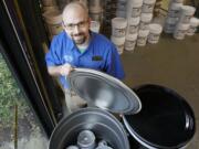 Tim Albright, a salesperson for the Orchards Miller Paint store, uncovers a container partially filled with recycled paint.