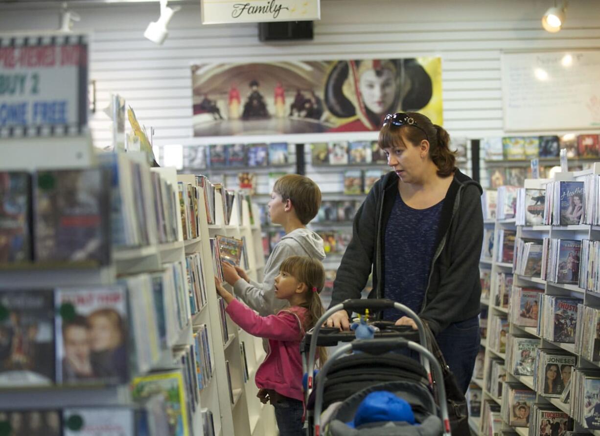 Chista Hendrickson looks for a movie with her children -- Tyler, 9, Mayah, 5, and twin 11-month-olds Dylan and Zachary, in stroller -- at Video Connections in Hazel Dell.