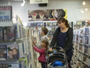 Chista Hendrickson looks for a movie with her children -- Tyler, 9, Mayah, 5, and twin 11-month-olds Dylan and Zachary, in stroller -- at Video Connections in Hazel Dell.