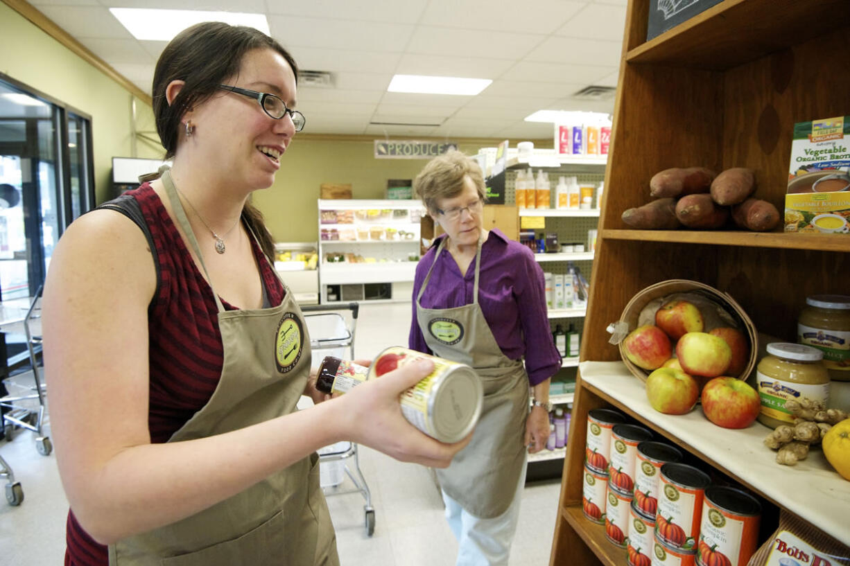 Claire Ghormley, new manager at the Vancouver Food Co-op store, adds grocery items to an end display featuring Thanksgiving favorites.