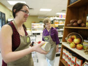 Claire Ghormley, new manager at the Vancouver Food Co-op store, adds grocery items to an end display featuring Thanksgiving favorites.