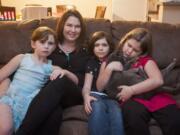 Angie Ballantyne gathers with her daughters -- from left, Alayna, 6; Ilisha, 7; and Melia, 9 -- at their home in Vancouver. Ballantyne&#039;s husband is serving a 25-year sentence in prison, and she and her family benefit from Families on the Outside, a nonprofit aimed at supporting families of prisoners.