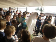 Photos by Steven Lane/The Columbian
Sixth-grader Mary Martiniello, center, playing Mary, joins other students in the Las Posadas procession Thursday at Our Lady of Lourdes Catholic School. The private school offers Spanish in a program that teaches proficiency through reading and storytelling.