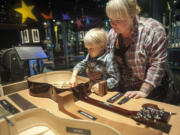 Nanny Summer Michaud-Skog checks out the guts of an acoustic guitar with her charge, 3-year-old Andrew, during a visit to &quot;Guitar: The Instrument that Rocked the World!&quot; at the Oregon Museum of Science and Industry.