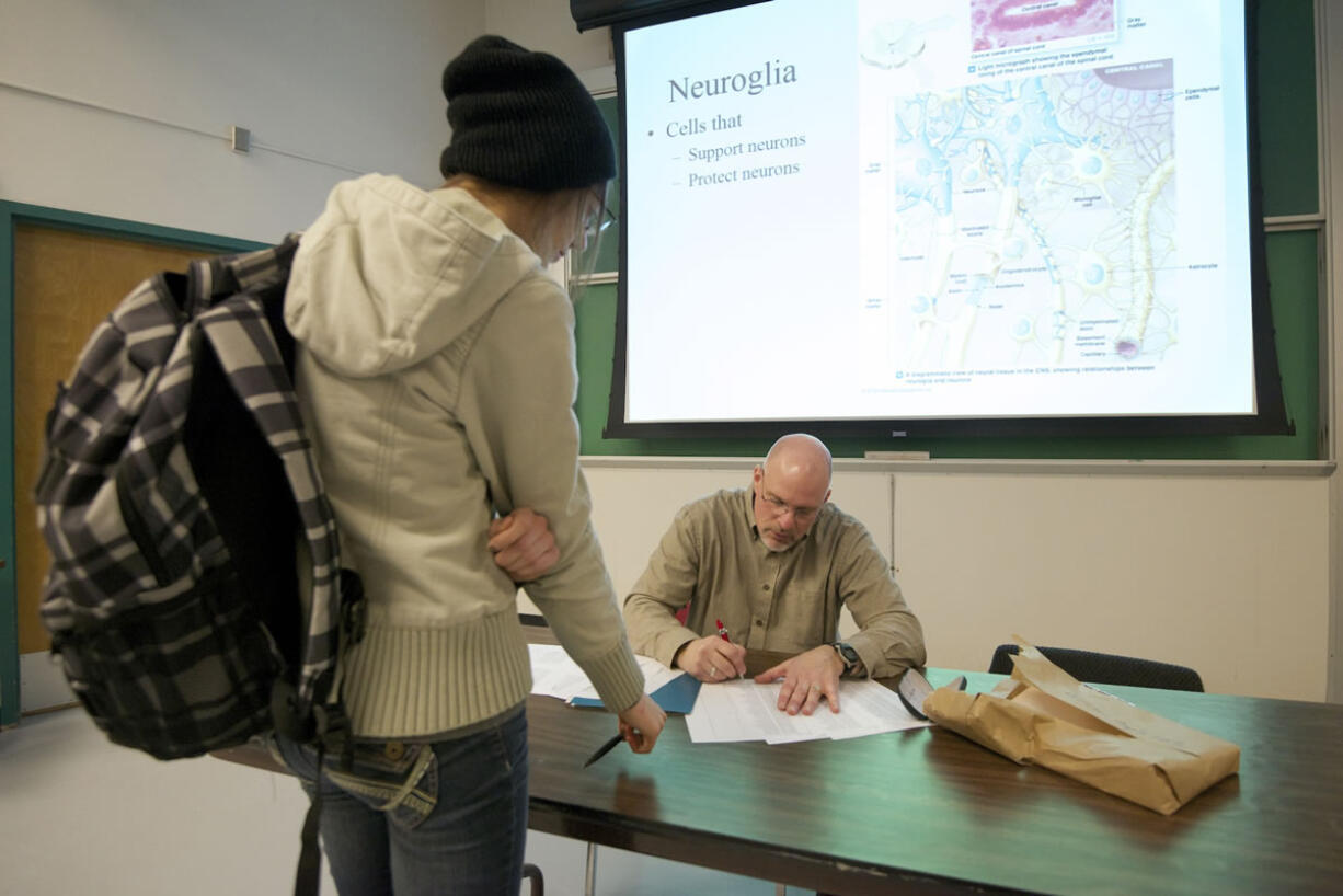 Clark College instructor Mark Bolke meets with student Margie Baron after a human anatomy and physiology class on the first day of winter term.