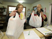 Bri Andrews, left, a single mom, and friend Travis Schmidt pick up emergency food bags at the East County Family Services Center on Tuesday in Washougal. The center has 300 families on record that it has helped since July.