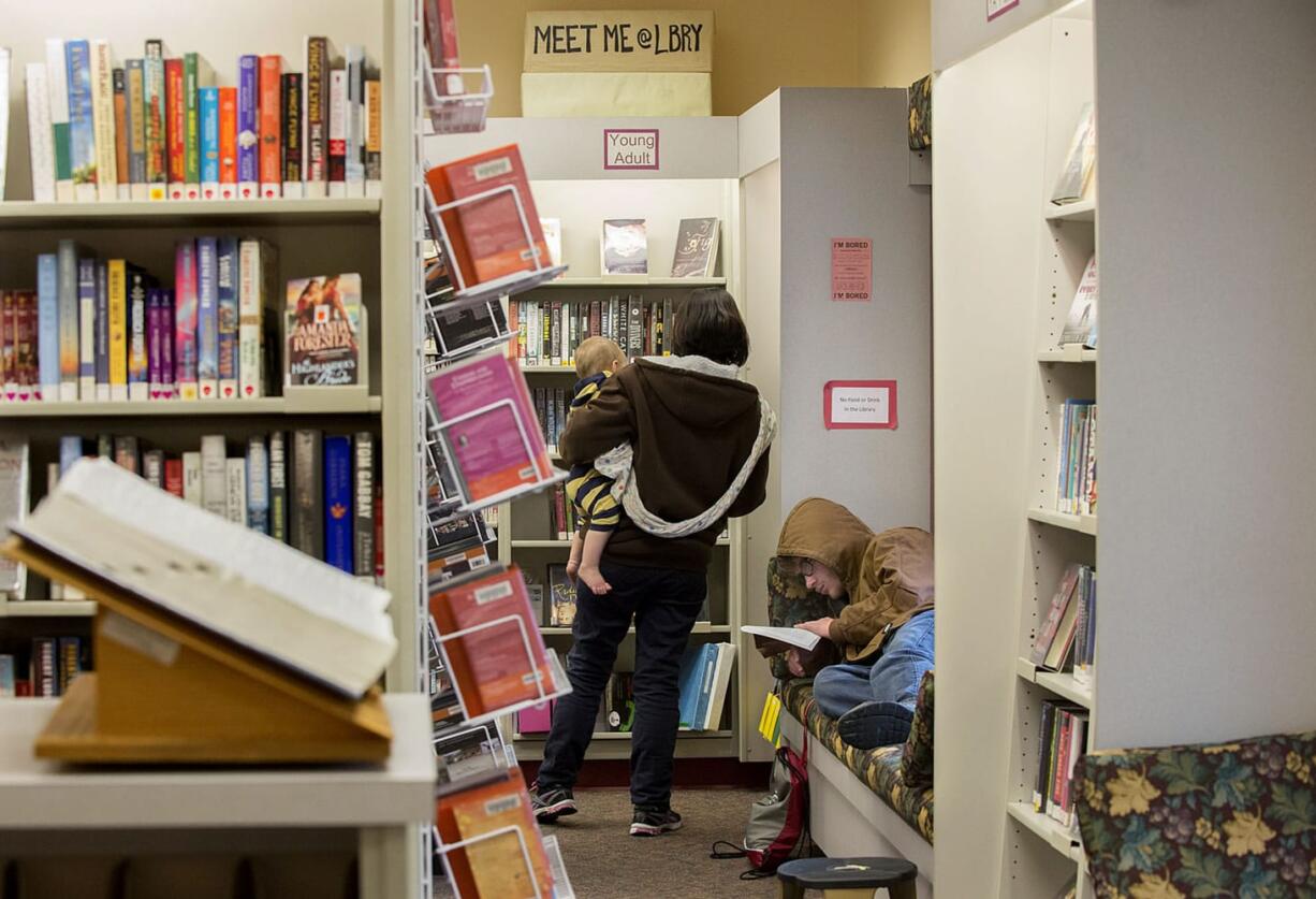 Luke Jarman, 1, left, and his mom, Amy, join Robert Sivewright in cramped quarters the morning of Nov. 19 at the Ridgefield Community Library. Fundraising is well underway for bigger and better libraries in the growing towns of Ridgefield, Washougal and Woodland.