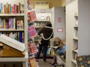 Luke Jarman, 1, left, and his mom, Amy, join Robert Sivewright in cramped quarters the morning of Nov. 19 at the Ridgefield Community Library. Fundraising is well underway for bigger and better libraries in the growing towns of Ridgefield, Washougal and Woodland.