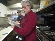 Joan Lacey, a food safety specialist with Clark County Public Health, records food temperatures during an inspection of Philly Bilmos Cheesesteaks as owner Michael Bitter watches. Lacey performs three unannounced inspections of the restaurant each year; it received a perfect score Jan.