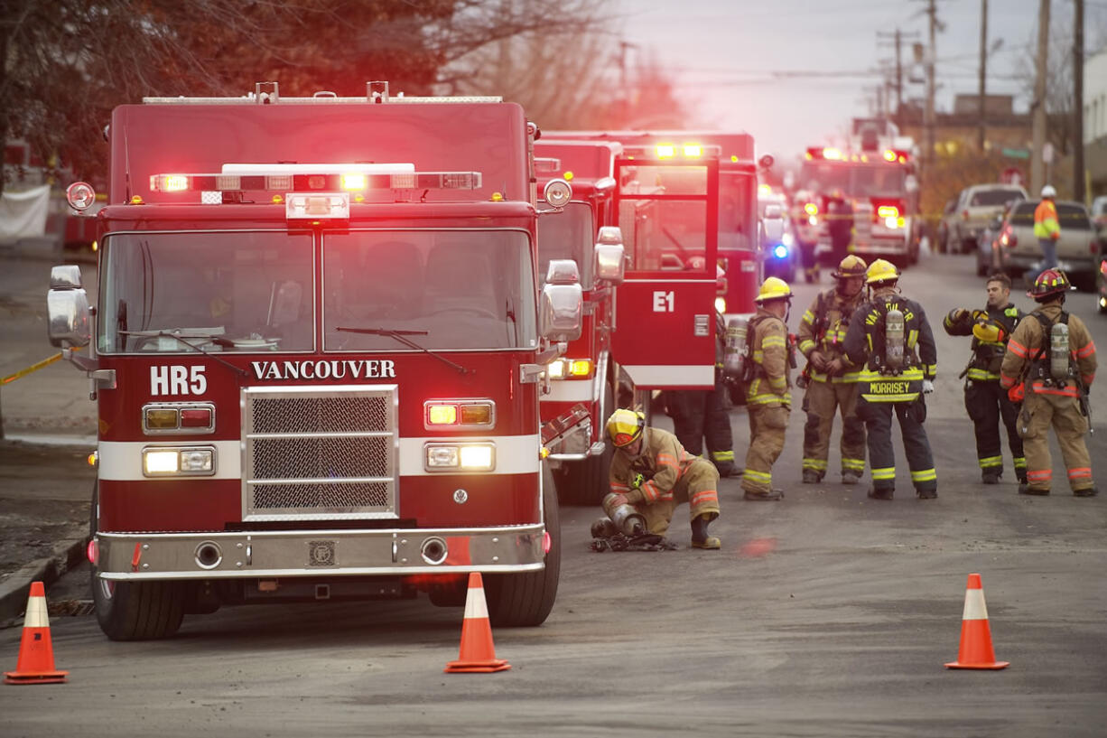 Firefighters with the Vancouver Fire Department stand by to investigate after a floor collapsed at Vancouver Warehouse and Distribution Co., 1101 W.