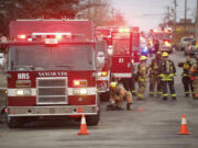 Firefighters with the Vancouver Fire Department stand by to investigate after a floor collapsed at Vancouver Warehouse and Distribution Co., 1101 W.