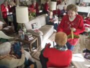 MaryAnn Cantrell, right, hands Virginia Christenson a card during the Evergreen Pollyannas Christmas party. The women met through a Girl Scout troop that they formed in 1948.