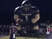 Camas High School's Jordan Del Moral (10) greets the crowd as he takes the field with teammate Jared Bentley (5) on Friday night, Oct. 16, 2015 at Doc Harris Stadium.