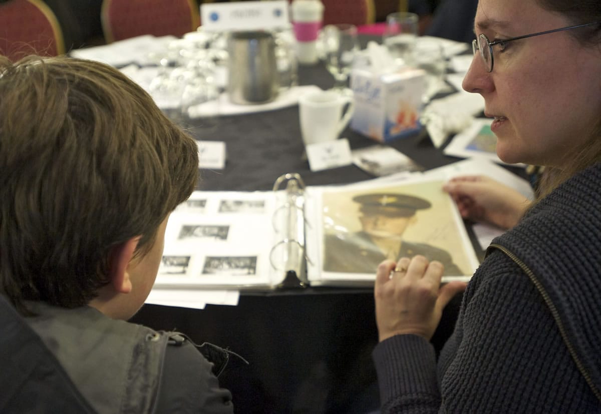 Kathy Stevens of Portland shows 14-year-old son Nathan Smith a photograph of her grandfather. Capt. John A. McAllaster was among the missing after his B-26 bomber went down over Korea on April 4, 1952. He also flew during World War II. They were part of a Saturday event for MIA families hosted by the Defense Department.