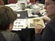 Kathy Stevens of Portland shows 14-year-old son Nathan Smith a photograph of her grandfather. Capt. John A. McAllaster was among the missing after his B-26 bomber went down over Korea on April 4, 1952. He also flew during World War II. They were part of a Saturday event for MIA families hosted by the Defense Department.