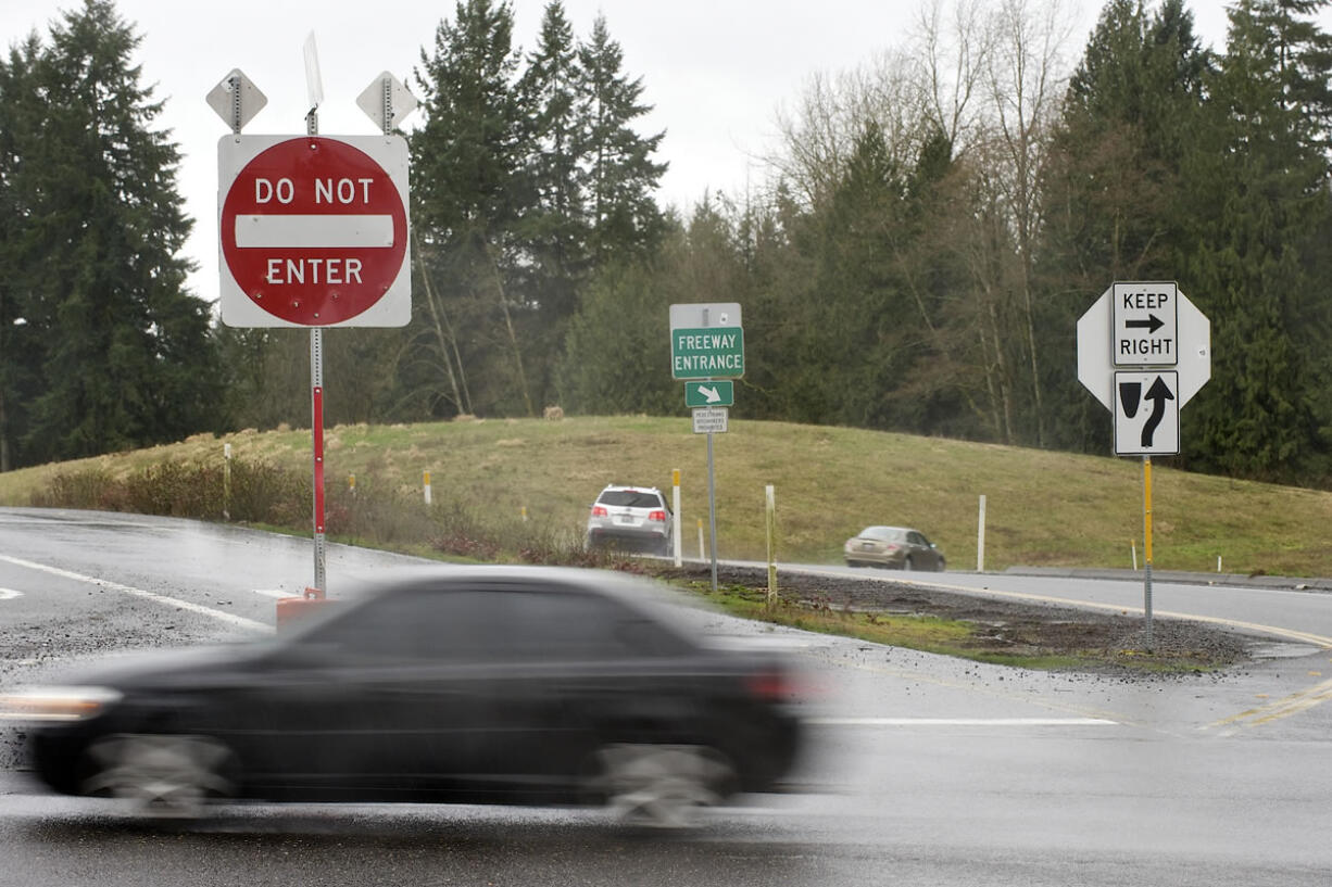 A series of signs provide information to motorists about onramps and offramps to Interstate 5 at Exit 11. It's possible a wrong-way driver entered there moments before a fatal crash on Feb. 28. At top, emergency crews work the scene of the Feb.