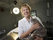 Carrie Burhenn, veterinarian and co-owner of Feline Medical Clinic, holds the clinic's foster cat Gracie.