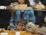 Rebekah Soft, top, and Reuben Soft examine artwork displayed at the grand reopening of the Fort Vancouver Visitor Center on Saturday.