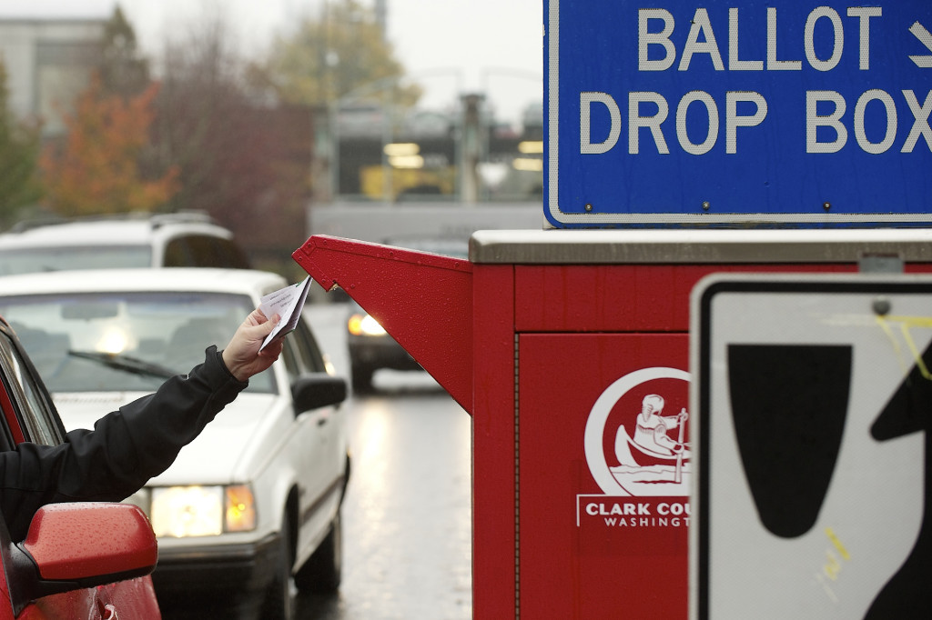 Voters use a drive-up collection box to cast their ballots Monday near the Clark County Elections Office, 1408 Franklin St., in downtown Vancouver.