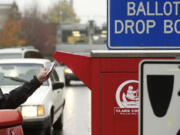 Voters use a drive-up collection box to cast their ballots Monday near the Clark County Elections Office, 1408 Franklin St., in downtown Vancouver.