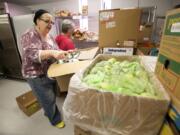 Volunteers Donna Cologna, left, and Sandra Ree stock the new One Life food pantry in advance of doors opening on Sunday afternoon.