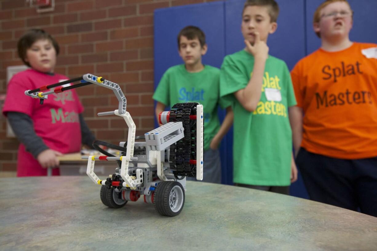 Splat Masters Tai McKinney, left, and Charlie Granlund prepare their Lego robot for competition.