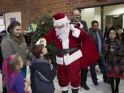 Santa greets children Thursday night at the annual Northeast Hazel Dell Holiday Party.