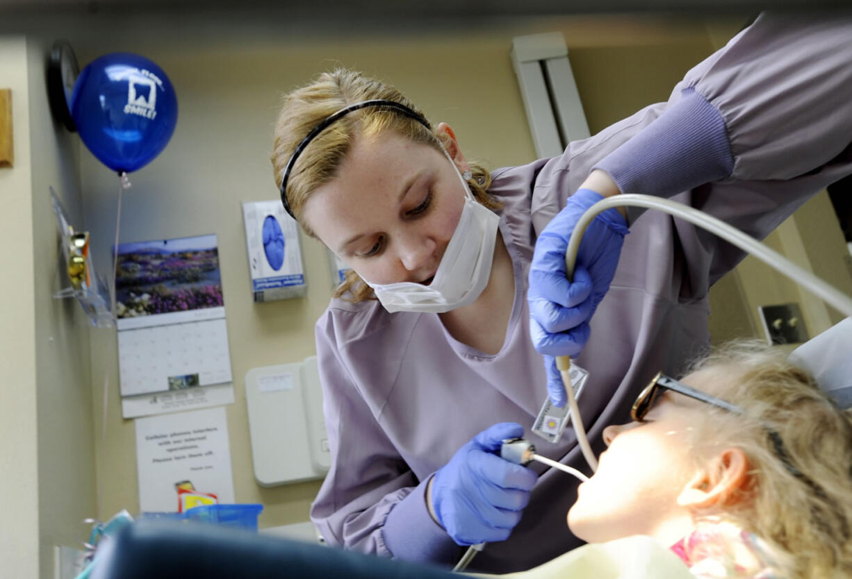 Dental assistant Jenna Bieber cleans Abbey Henkel's teeth at Wendel Dental in Vancouver.