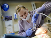 Dental assistant Jenna Bieber cleans Abbey Henkel's teeth at Wendel Dental in Vancouver.