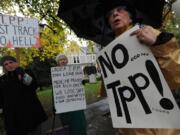 Dorethea Simone, right, and others protest against the Trans Pacific Partnership along Fort Vancouver Way in Vancouver on Thursday.