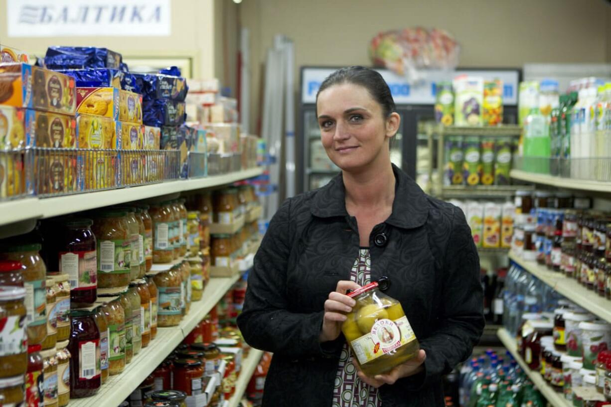 Galina Burley holds a jar of pickled apples as she talks about Russian party food at Anoush Deli in Vancouver.