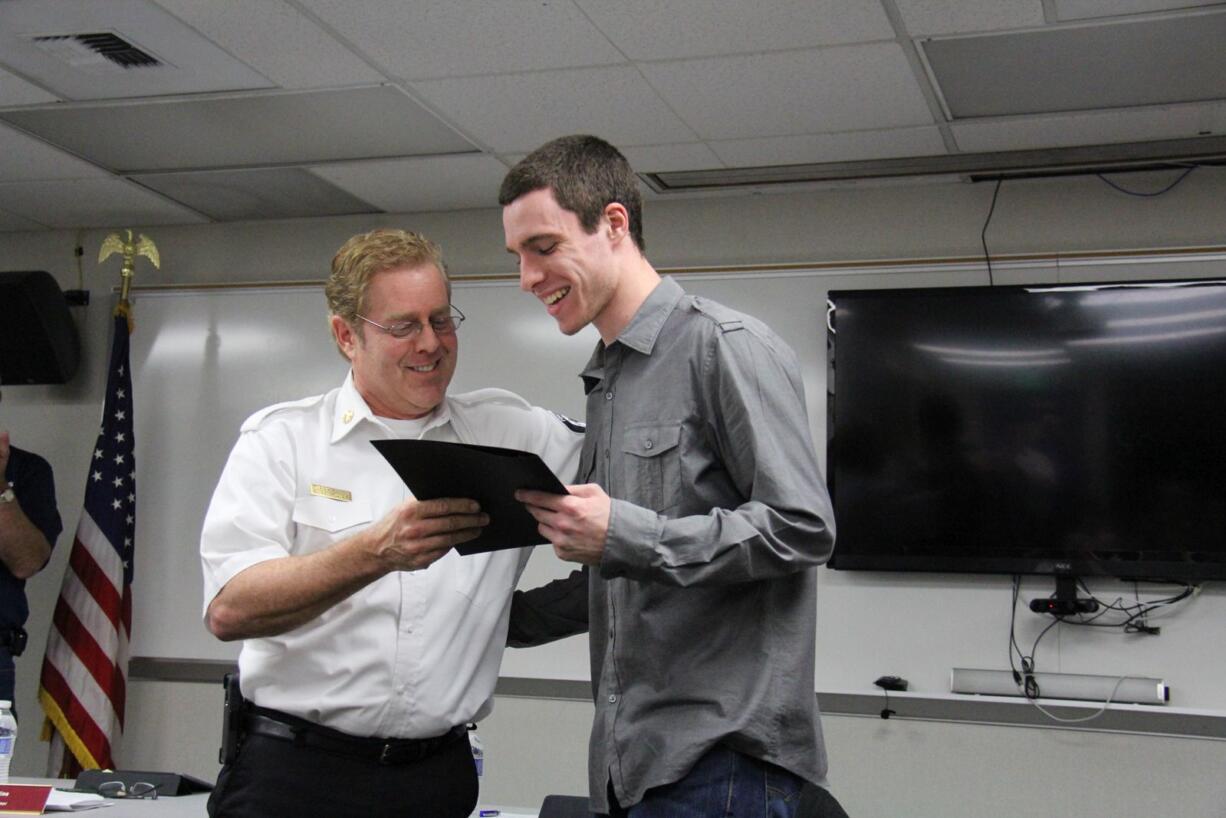 Fire District 6 Chief Jerry Green hands Carter Coval, 17, a life-saving award Tuesday for rescuing a 5-year-old boy from drowning in December.