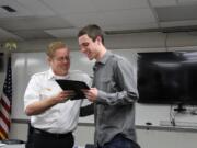 Fire District 6 Chief Jerry Green hands Carter Coval, 17, a life-saving award Tuesday for rescuing a 5-year-old boy from drowning in December.