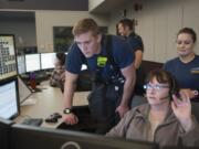 Dispatcher Robin Bardon, right, shows rookie firefighter Spencer Vadney how 911 calls are handled Nov. 17 at the Clark Regional Emergency Services Agency in Vancouver. In 2014, the most common calls were incomplete calls.