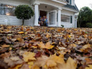 Justin Valdivia, 12, relaxes with his dad, Arnie, as they enjoy lunch overlooking a carpet of fallen leaves Friday afternoon in Vancouver&#039;s Carter Park neighborhood.