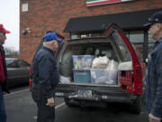 George Golden, center, director of LINKS, Michael Rankin, left, and Don Meuchel pick up perishable food items at a 7-Eleven in Vancouver on Friday.