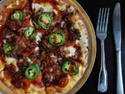 Bold, satisfying Muscle Man pizza is topped with jalapeño cream cheese, mozzarella cheese, Italian sausage, bacon and pepperoni -- all drizzled with a chipotle raspberry glaze and finished with fresh, thinly sliced jalapeños -- Nov. 13 at the South Pacific Cafe in Battle Ground.